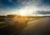 White SUV parked on a rural road at sunset
