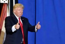 man in suit giving two thumbs up