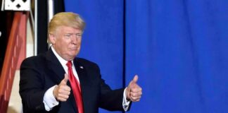 man in suit giving two thumbs up