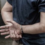 person in handcuffs with hands behind back