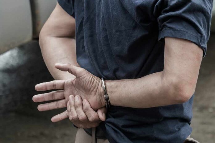 person in handcuffs with hands behind back