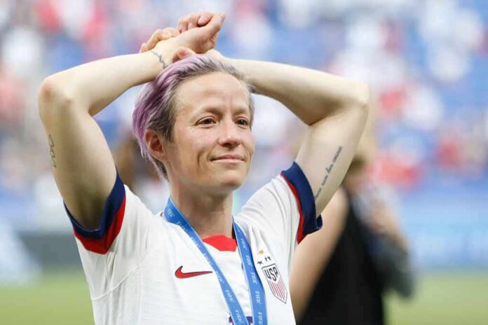 Soccer player with purple hair smiling with hands on head