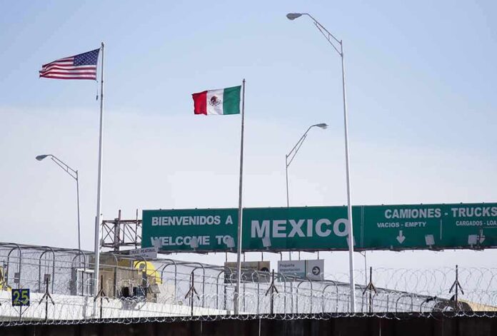 Border crossing with U.S. and Mexico flags and a sign welcoming to Mexico