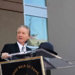 Bill Maher Draws A Line On Socialism A man in formal attire speaking at a podium during a Hollywood Walk of Fame ceremony