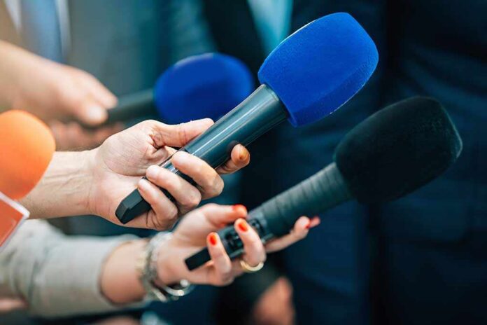 Reporters holding colorful microphones