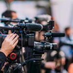 Money-Launder Flags Trigger Trump Purge Video cameras on tripods at a media event