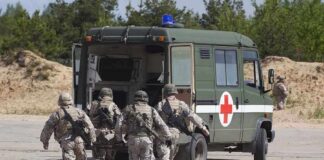 Soldiers running towards a medical vehicle during a military operation