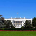 The White House facade with flag and gardens