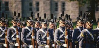 Group of uniformed cadets marching with rifles; named individuals: Zach Zenner, Griff Whalen, Patrick DiMarco, Freddie Williams II, Daryl Smith, Timmy Jernigan, Walter Jones