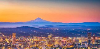 City skyline at dusk with mountain in the distance
