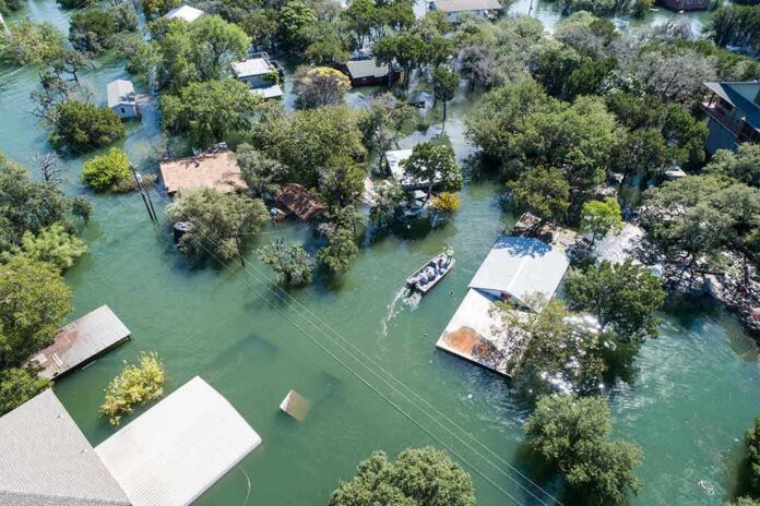 Aerial view of flooded neighborhood with rescue boat navigating streets