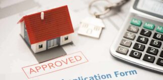 Mortgage application form with approved stamp, model house, and calculator
