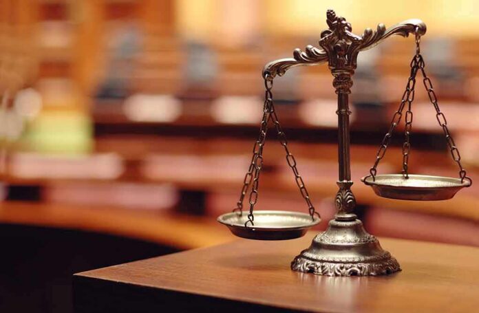 shutterstock_140867215 bronze balance scales on a courtroom desk