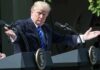 Donald Trump speaking at dual podiums with arms outstretched