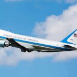Air Force One aircraft ascending against a blue sky