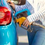 Security Over Savings? Trump Doubles Down Person refueling a blue car with a yellow gas nozzle