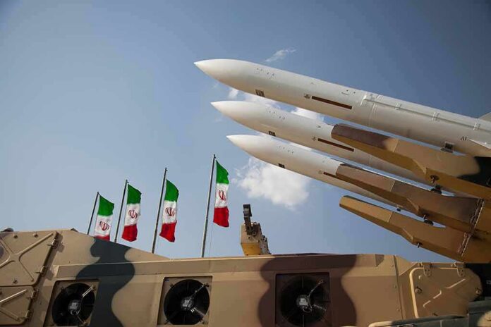 Missile launchers on a military vehicle with flags in the background