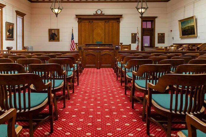 shutterstock_1631139556 Courtroom with wooden benches facing the judge's bench