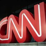 Large red CNN logo outside a modern building entrance