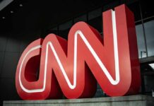 Large red CNN logo outside a modern building entrance