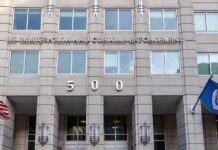 Deportations Go Wider Than ‘Criminals Only’ US government building facade with flags and number 500