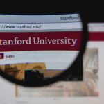 Close-up view of Stanford Universitys website through a magnifying glass