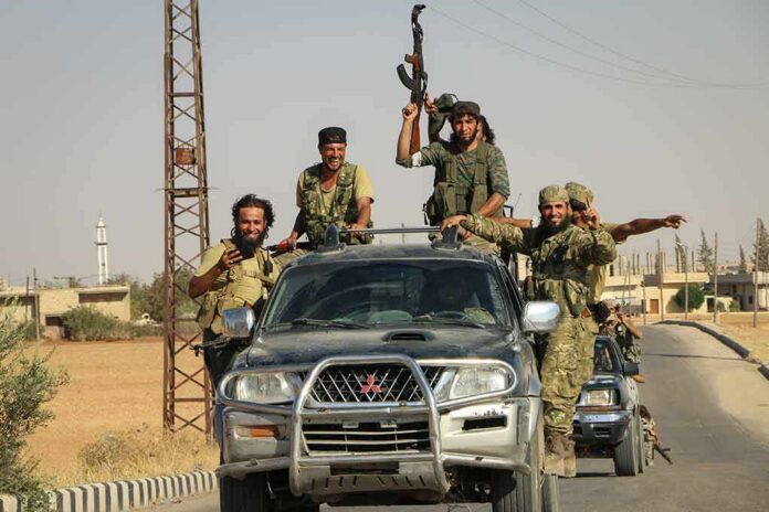 armed men riding on pickup trucks in a convoy