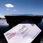 Election Mail Showdown: Power Grab Alleged Mail-in ballot being inserted into a blue USPS mailbox