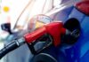 Red gasoline nozzle fueling a blue car