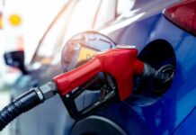 Red gasoline nozzle fueling a blue car