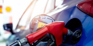 Red gasoline nozzle fueling a blue car