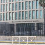 Embassy building behind tall black security fence