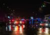 Nighttime police scene with flashing lights on a wet city street