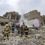 Firefighters search rubble of a partially collapsed building