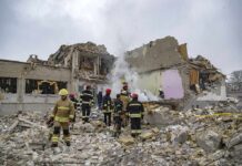 Firefighters search rubble of a partially collapsed building