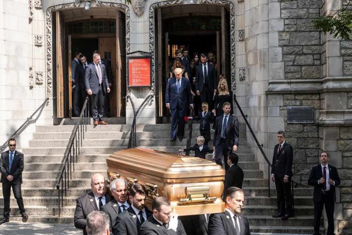 shutterstock_2180696039 Pallbearers carry a casket down church steps