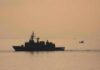naval ship silhouette at sea during sunset