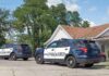 Two police SUVs parked near a suburban house
