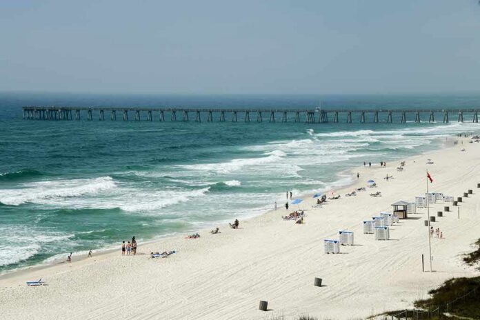 shutterstock_2281578699 Sandy beach with turquoise waves and a long pier