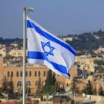 Israeli flag waving over a cityscape