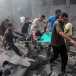 Explosions After Shaking—Rescuers Race The Clock Rescuers carry an injured person on a stretcher through rubble