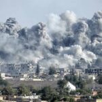 Refinery Hit As Swarm Overwhelms Defenses Massive smoke plumes rise over a city after explosions