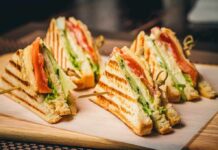 Your BLT Just Became a Policy Debate Club sandwich quarters on a wooden board