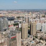 Aerial view of a sprawling urban city with high-rise buildings and green spaces