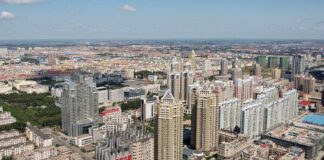 Aerial view of a sprawling urban city with high-rise buildings and green spaces
