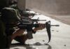 Soldiers lying prone firing rifles at a shooting range