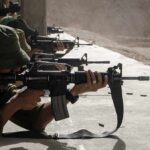 Soldiers lying prone firing rifles at a shooting range