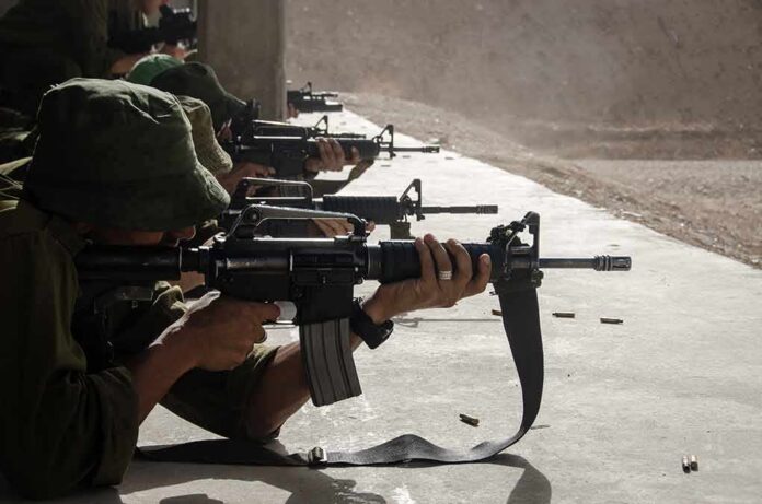 shutterstock_512193916 Soldiers lying prone firing rifles at a shooting range
