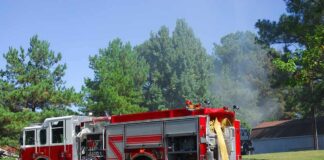 Fire truck parked on suburban street with hoses deployed