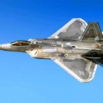 Stealth fighter jet in flight against a clear blue sky